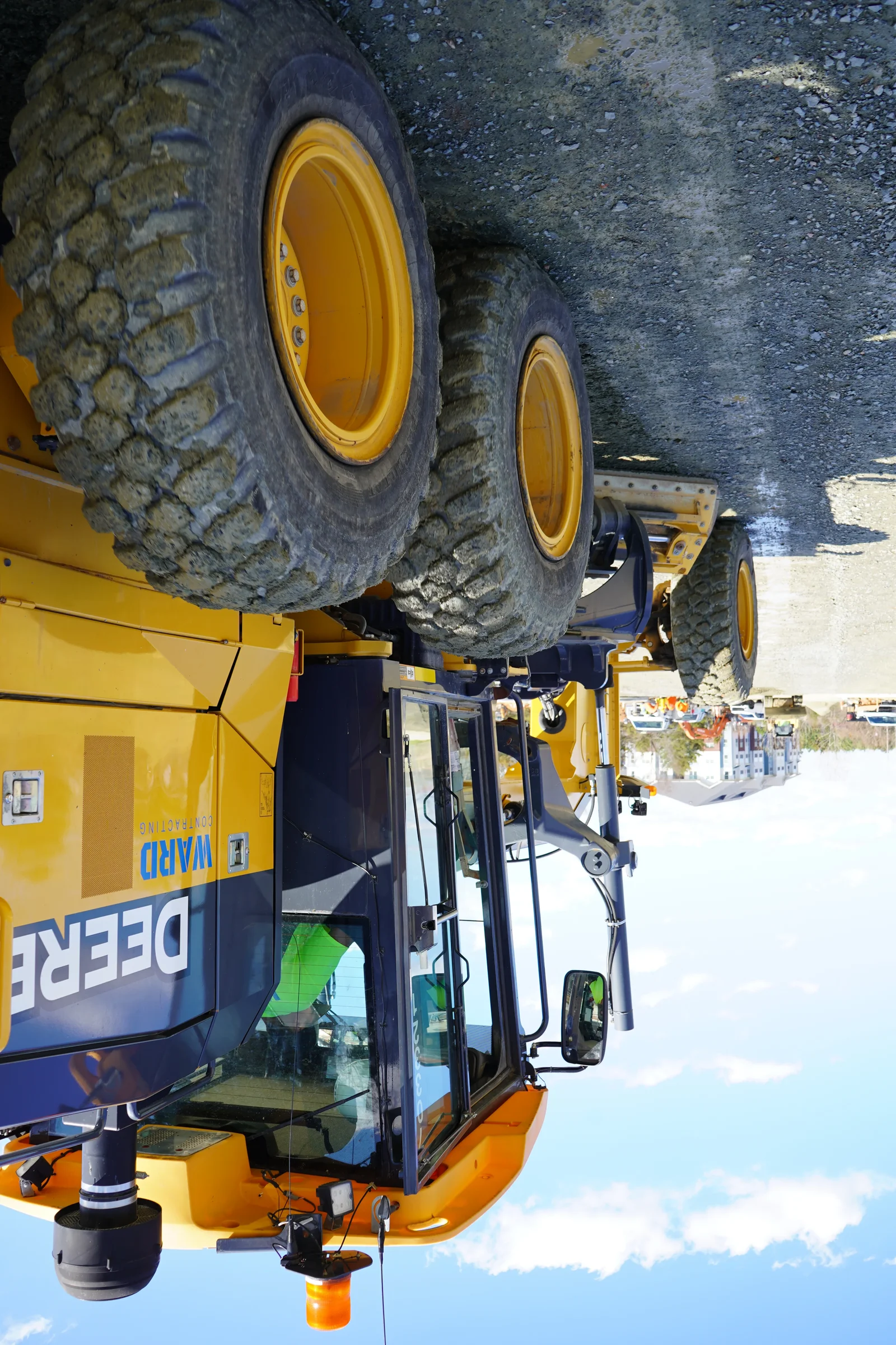 Yellow articulated dump truck with large tires and reinforced frame on gravel surface
