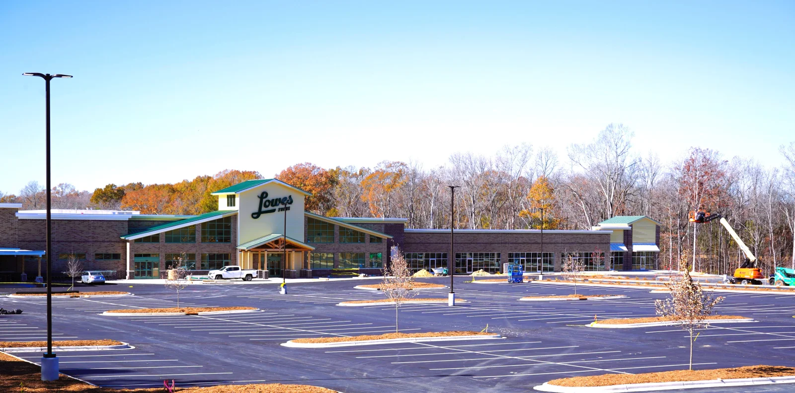 Newly paved commercial asphalt parking lot with white striping and landscaped islands
