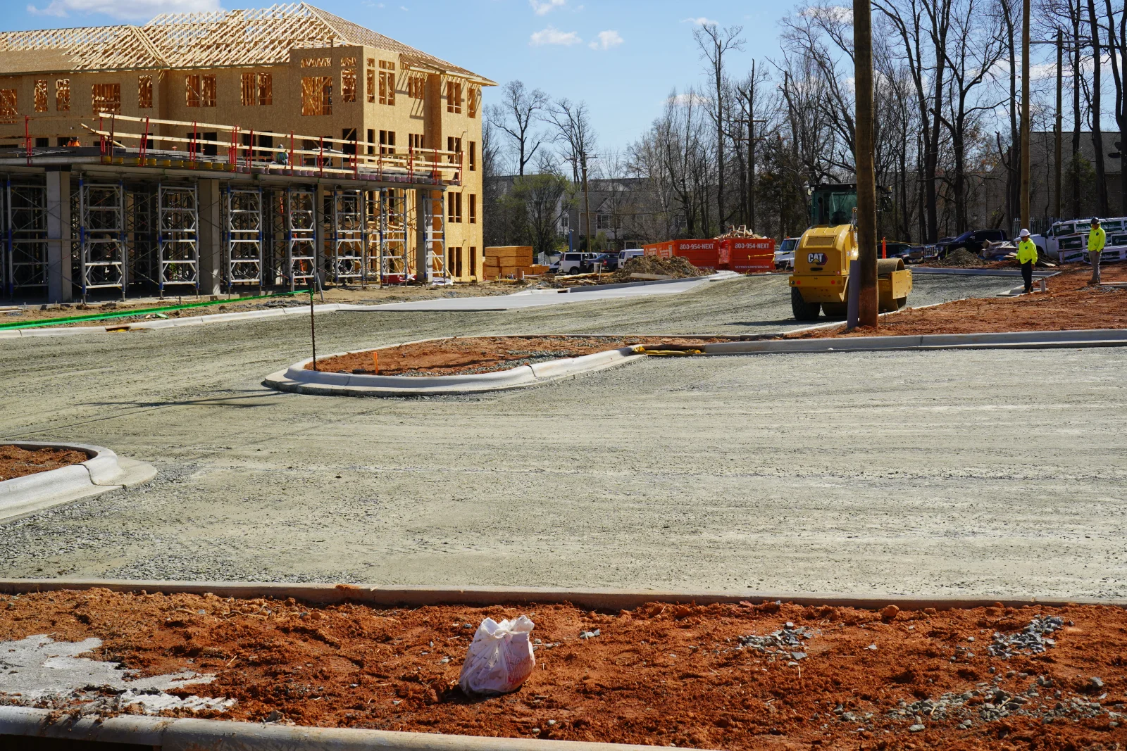 Asphalt paving and site preparation with concrete curbing at commercial construction site