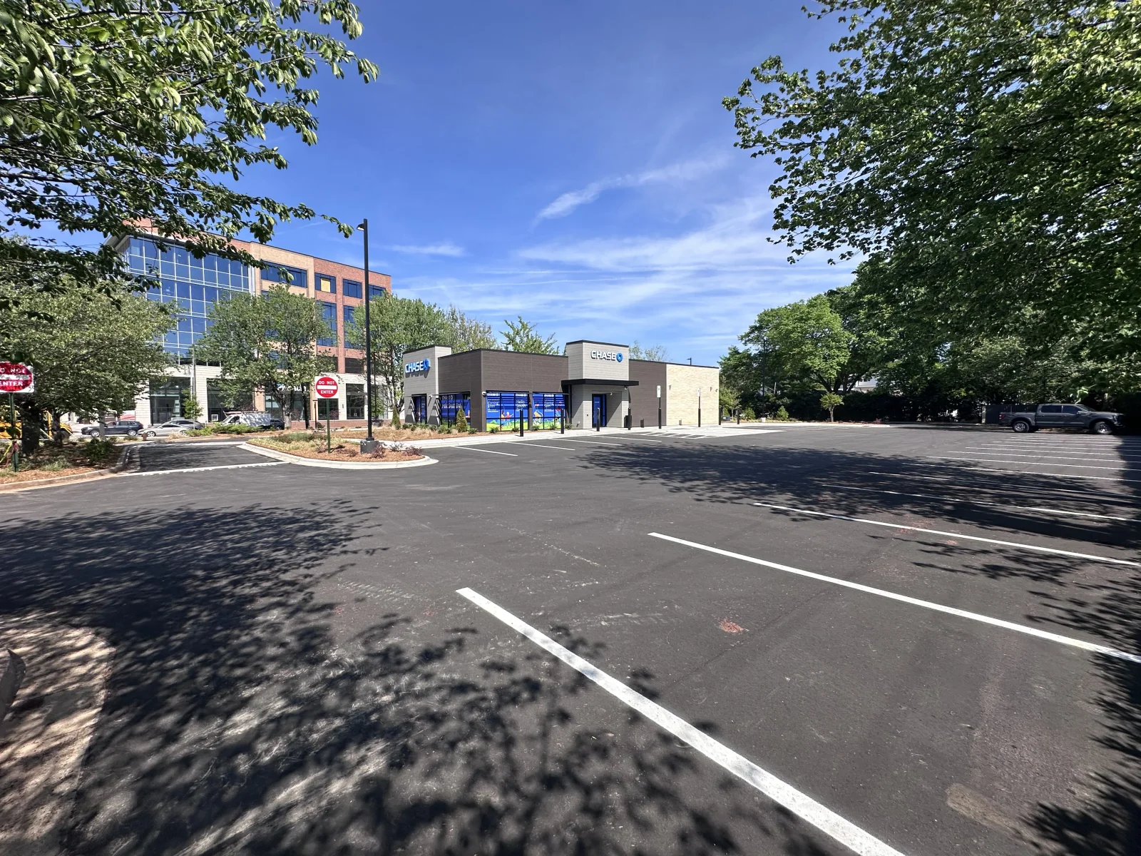 Newly paved asphalt parking lot with white striping and landscaped islands