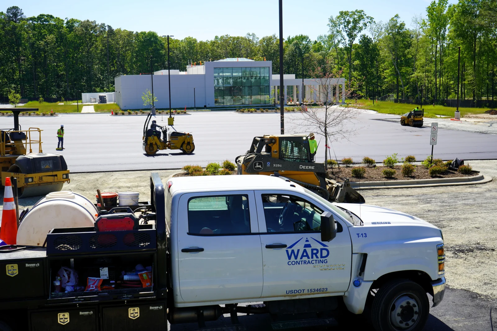Asphalt paving crew with compaction equipment and fresh-laid parking lot surface
